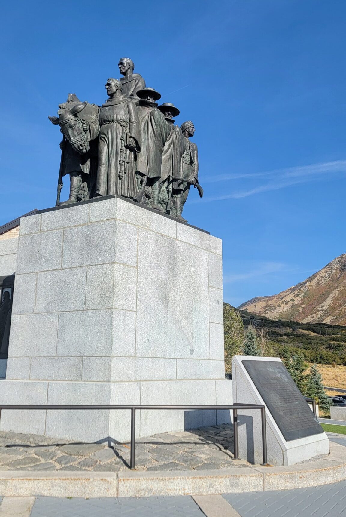 Photo of a statue of Domínguez and Escalante on a sunny day with blue sky and mountains in the background