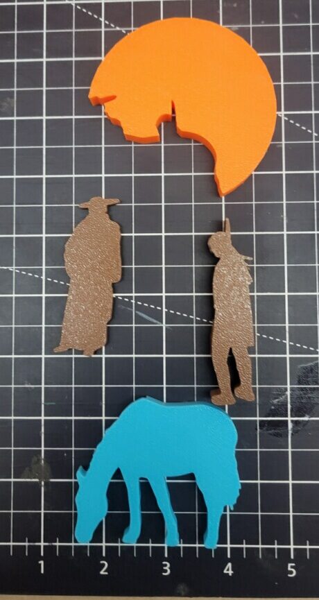 Silhouettes of a Franciscan, a Native American, a horse, and an orange crescent shape on a grid mat.